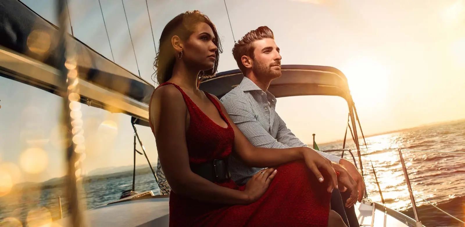 Elegant couple cruising on open marina waters at golden sunset near Capeside Marina Residences Siniya Island.
