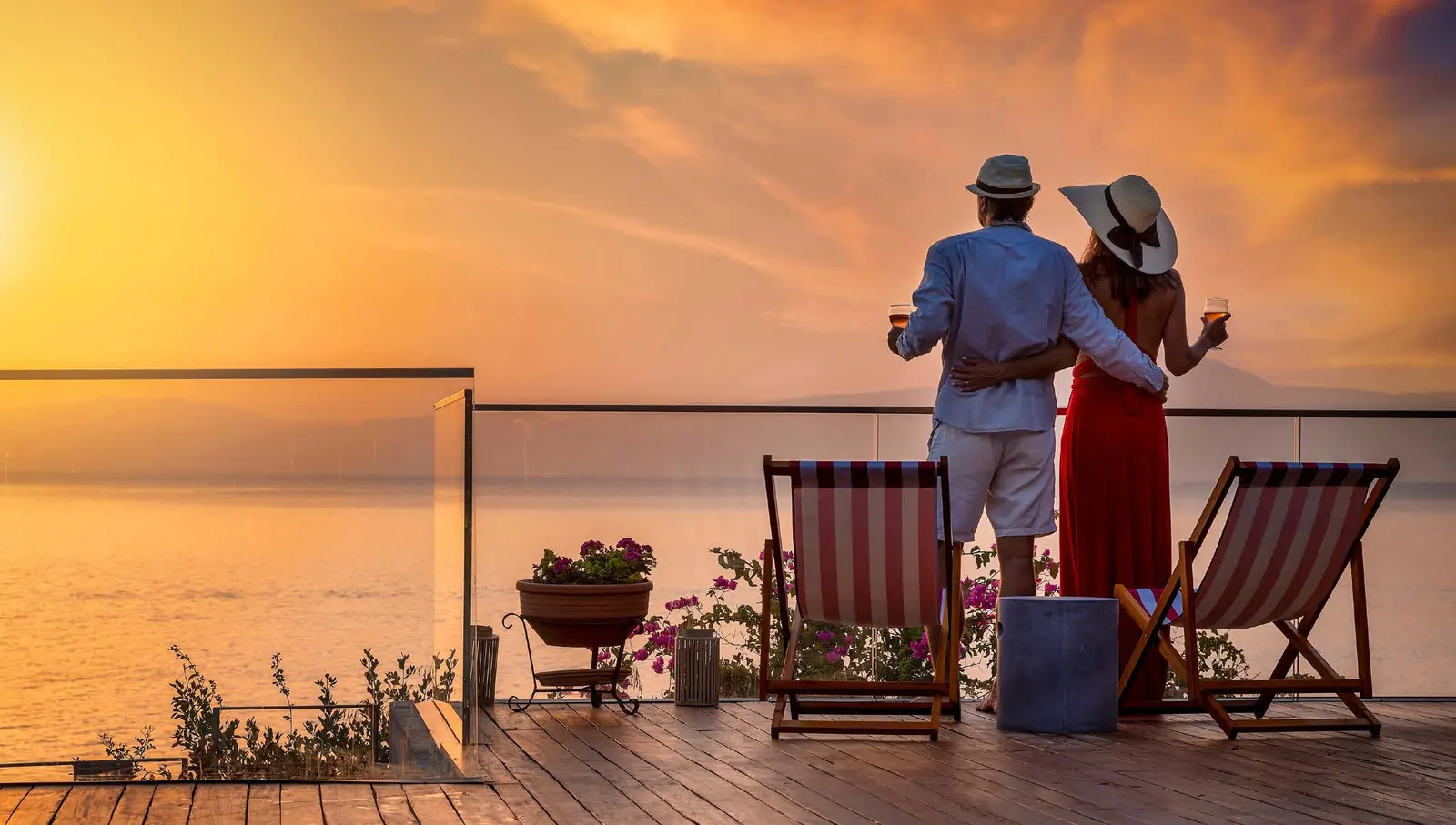 Couple relaxing on a private timber sunset deck overlooking shimmering marina horizons at pearlside Marina Residences Sobha Siniya Island.