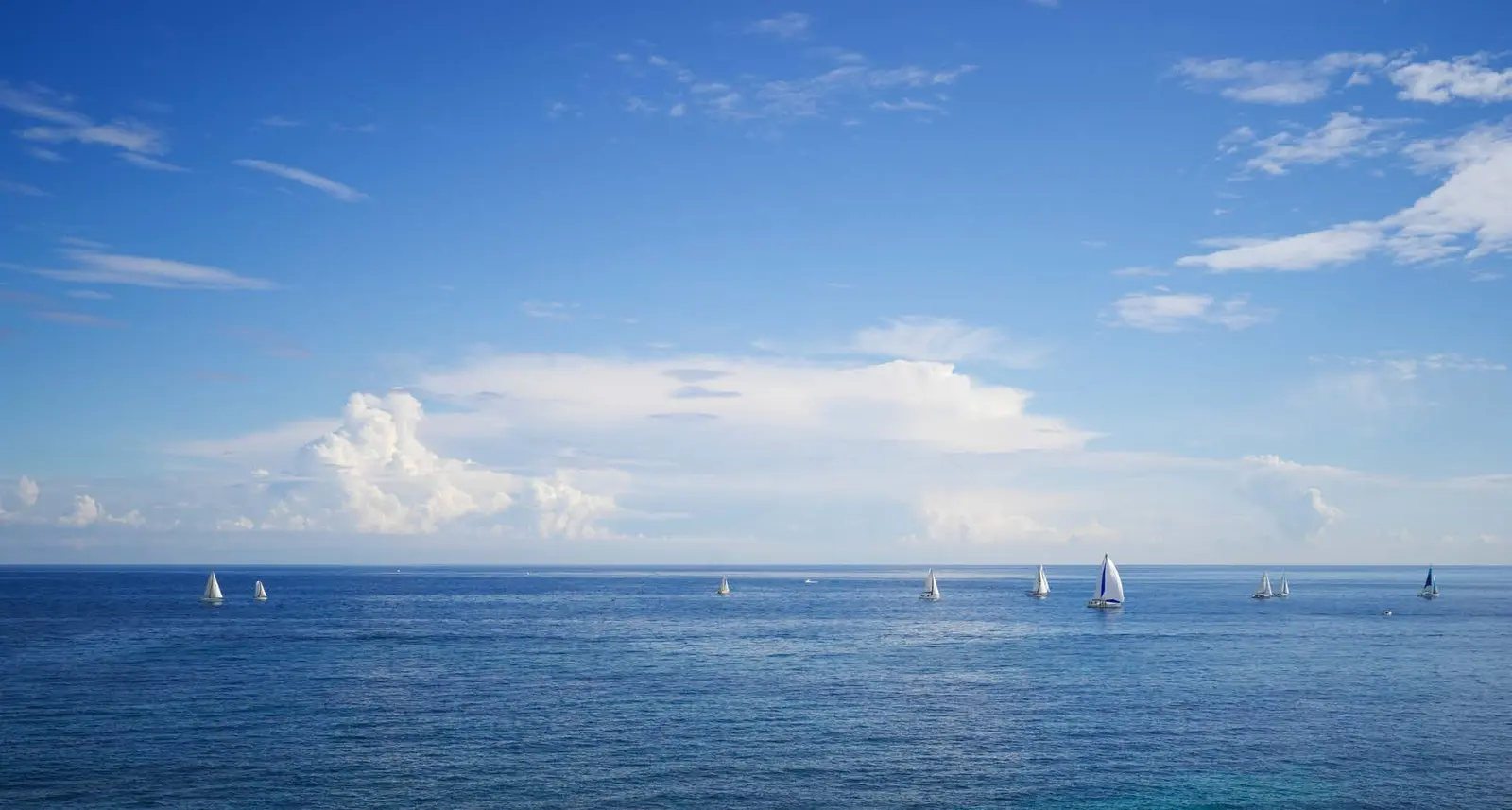Panoramic open blue sea horizons with sailing boats bordering coastal paradise at pearlside Marina Residences Siniya Island.
