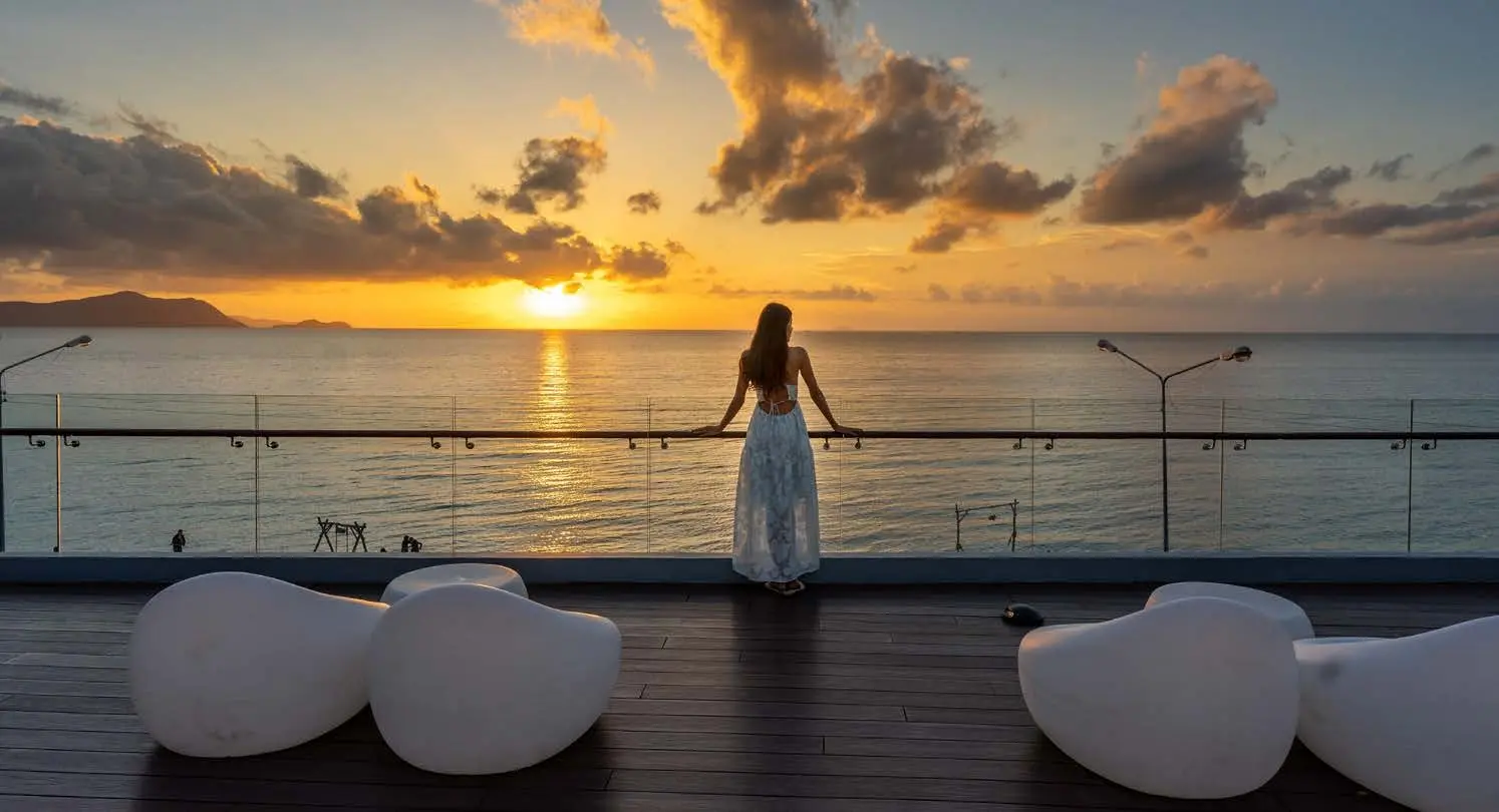 Woman enjoying breathtaking golden sunset ocean horizons from viewing deck at Pearlside Marina Residences Sobha Siniya Island.