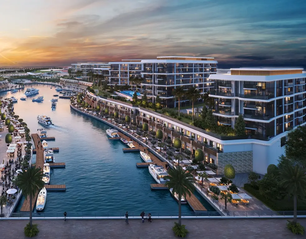 Dusk aerial view of the illuminated canal and residential buildings at Bayside Marina Residences on Sobha Siniya Island