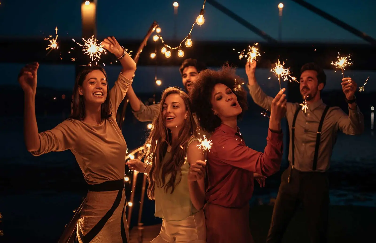 Evening celebration with sparklers at outdoor waterfront deck near Pierside Marina Residences Sobha Siniya Island UAQ