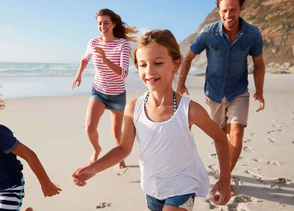 Family spending quality time together on private white sand beach at Pierside Marina Residences Sobha Siniya Island UAQ